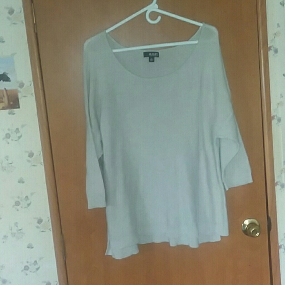 A tan off shoulder sweater with 3/4 sleeves